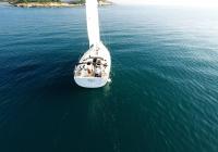 sailing yacht stern steering to island sea